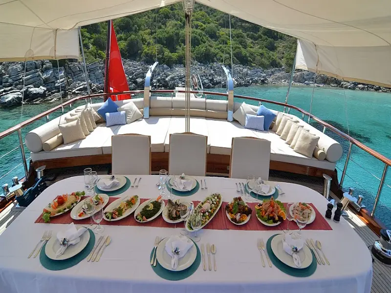 Ekmar Yachting Blue Heaven Gulet Yacht Anchored In Bay Al Fresco Dining Area With Food On Dishes Ready To Lunch View